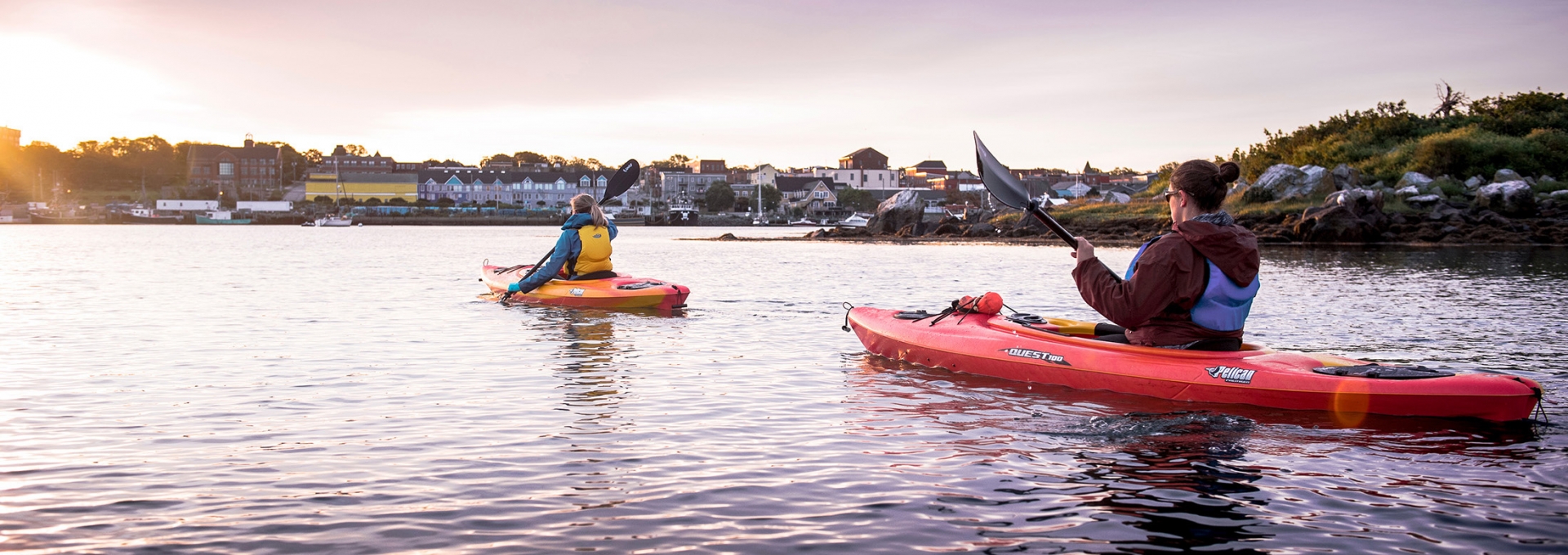 Two people in separate kayaks at sunset