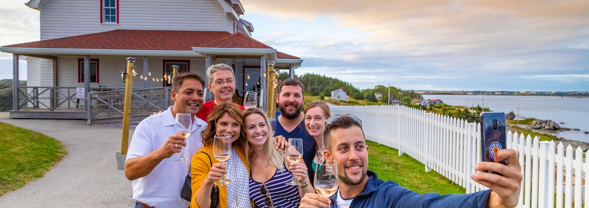 A group taking a selfie with glasses of wine