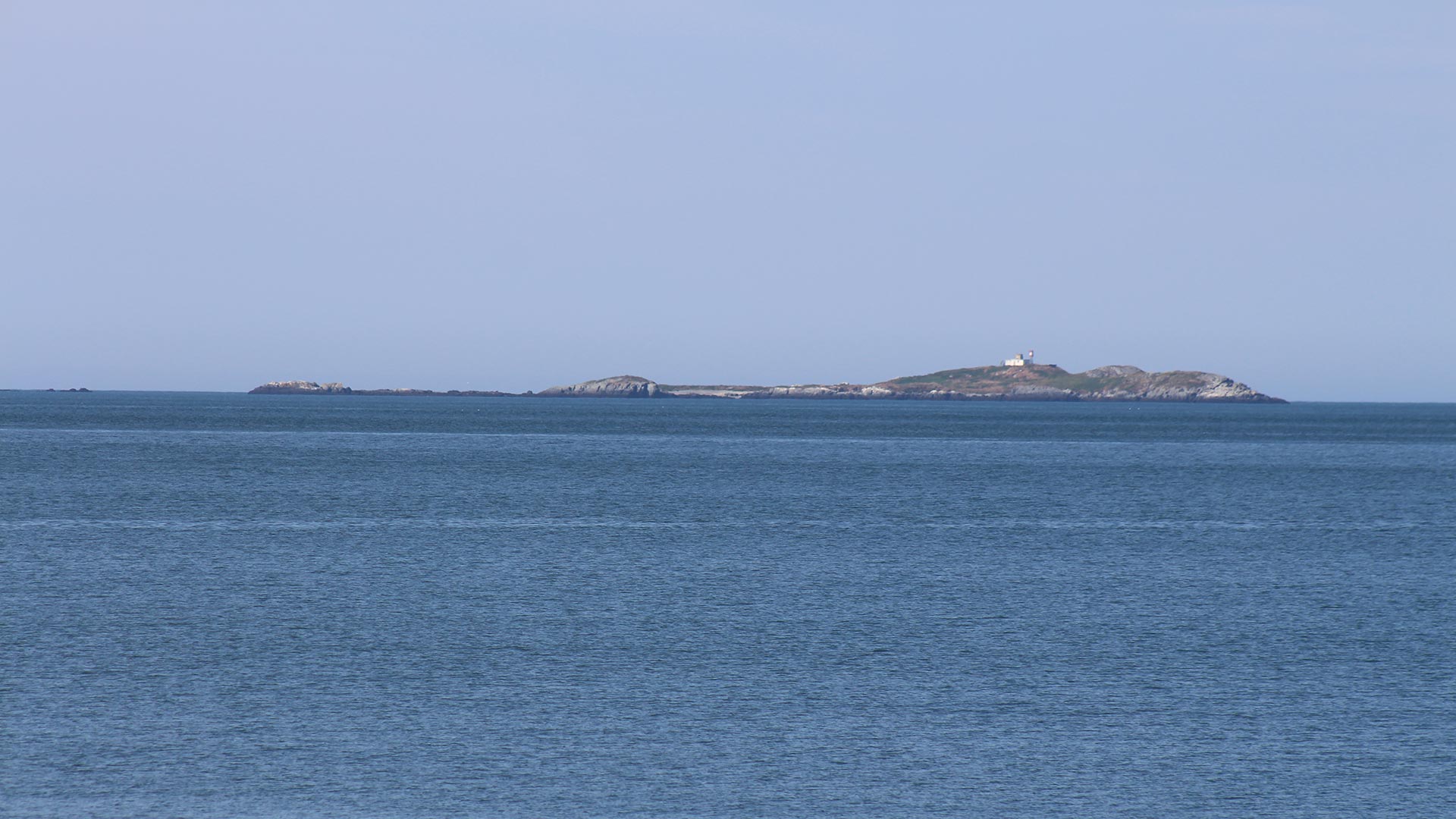 A small island surrounded by blue water